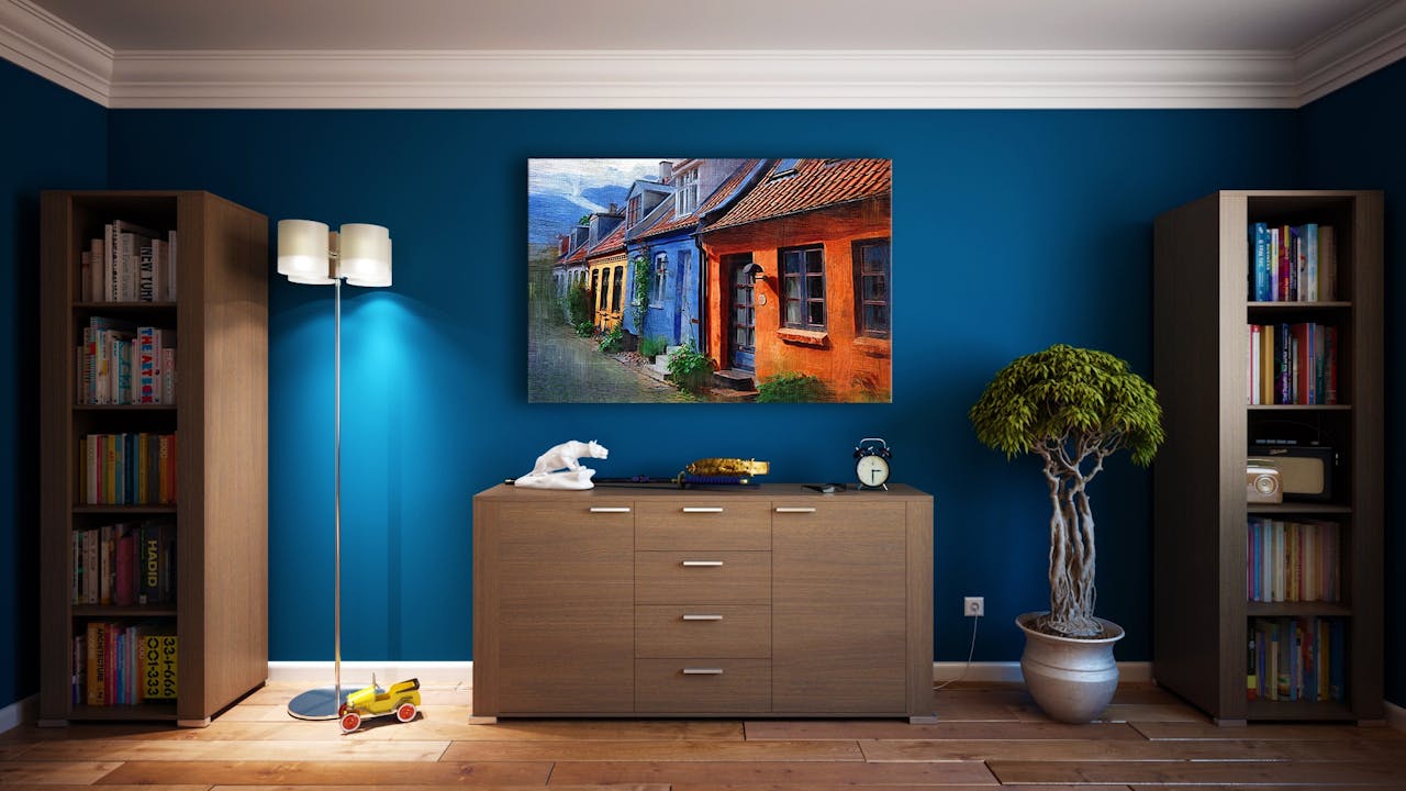 our-story A modern living room featuring stylish bookshelves, a vibrant painting, and minimalistic decor.